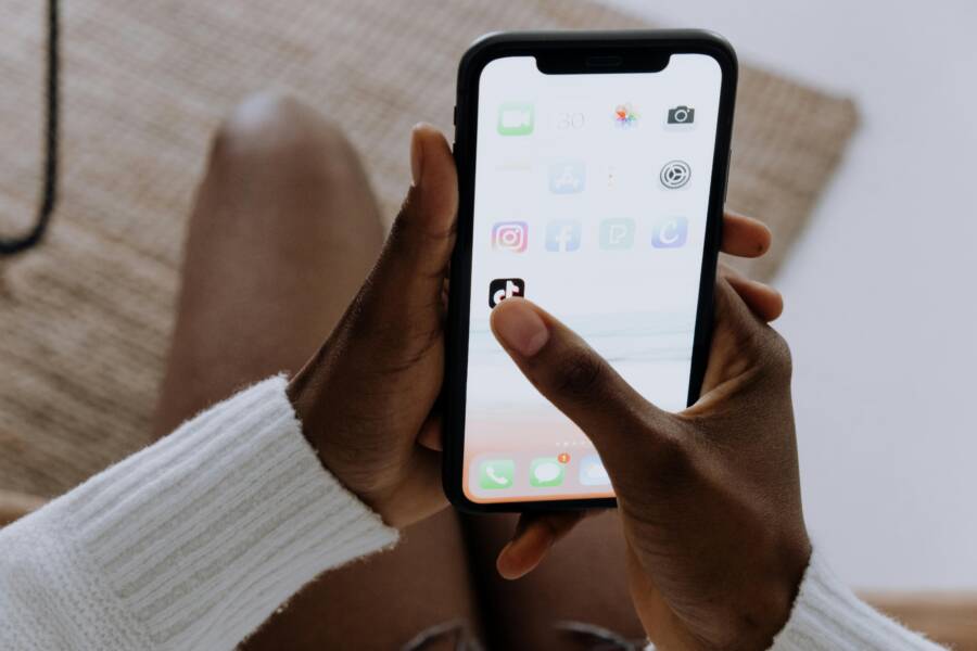 Close-up of hands with a smartphone using TikTok indoors