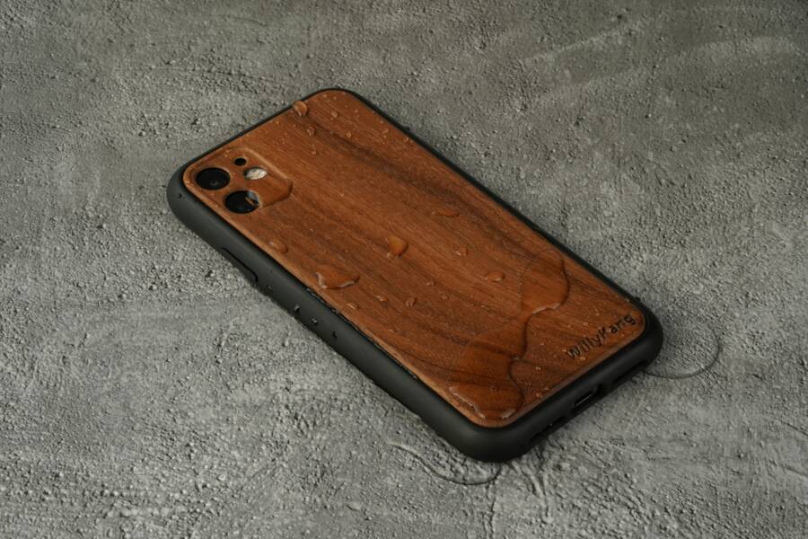A stylish wooden smartphone case showcasing water resistance on a textured surface.