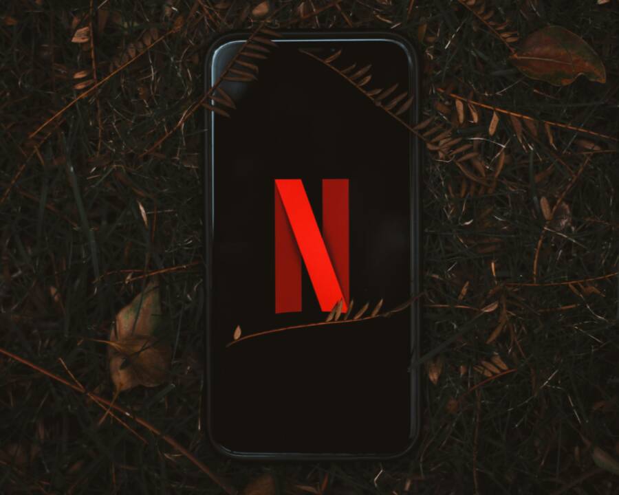 Smartphone with Netflix logo on screen, outdoors