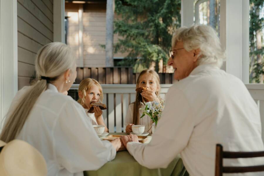Grandparents enjoying quality time with their grandchildren at a patio table.