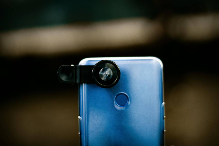 A detailed view of a smartphone with a detachable lens, emphasizing mobile photography.