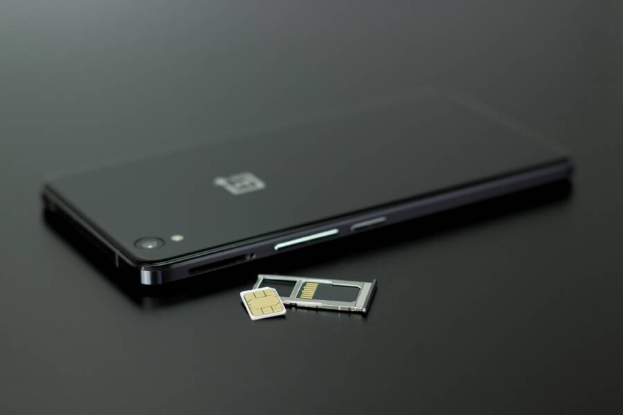 How to Fix WhatsApp Not Recognizing Your Phone Number: A Practical Verification Guide Close-up of a smartphone with a SIM card and memory card, showcasing modern technology.