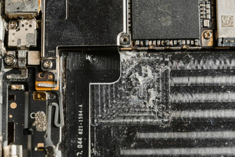 Detailed close-up of a dusty mobile phone circuit board showcasing various electronic components.