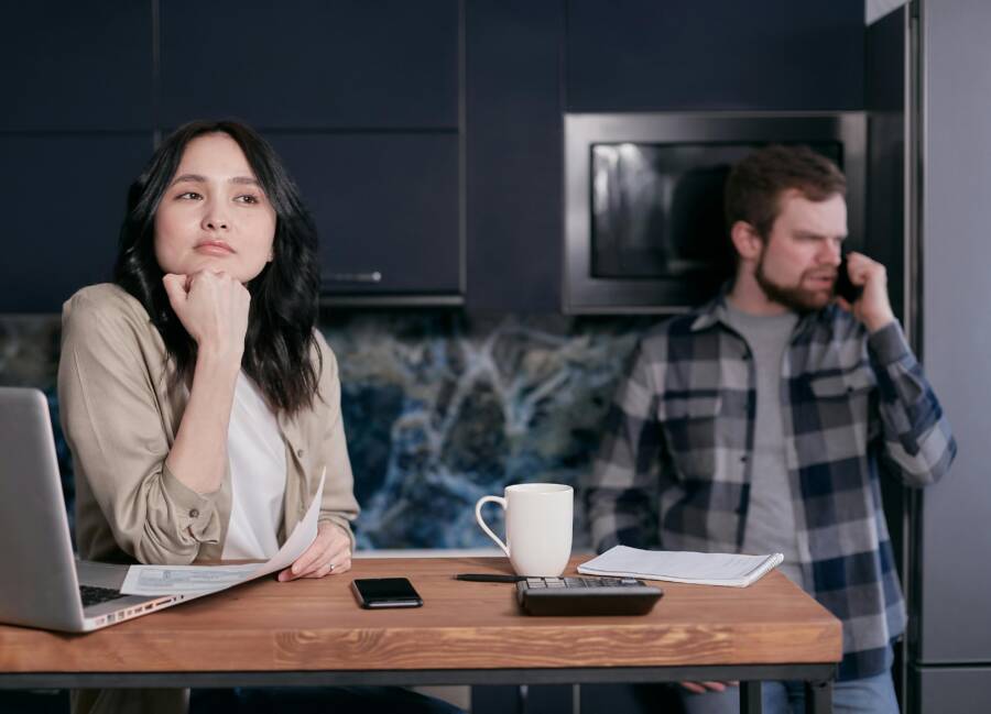 A couple in their kitchen, focused on financial planning and budgeting, showcasing stress and teamwork