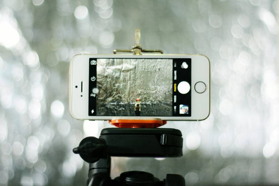 Close-up of a smartphone on a tripod, capturing an outdoor scene