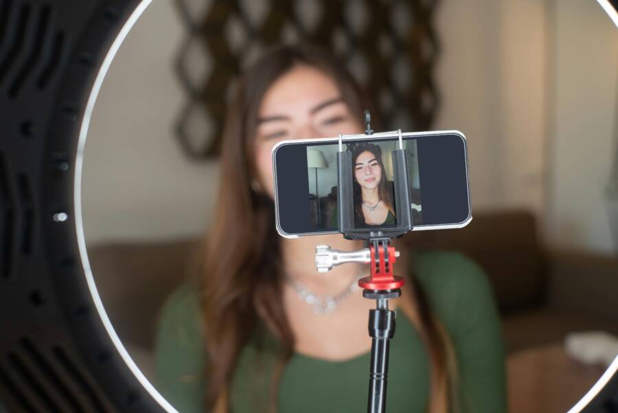 A close-up of a phone being used as a webcam in a home office setup