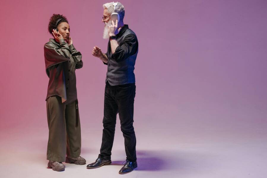 Two professionals testing wireless headphones in a studio setting.