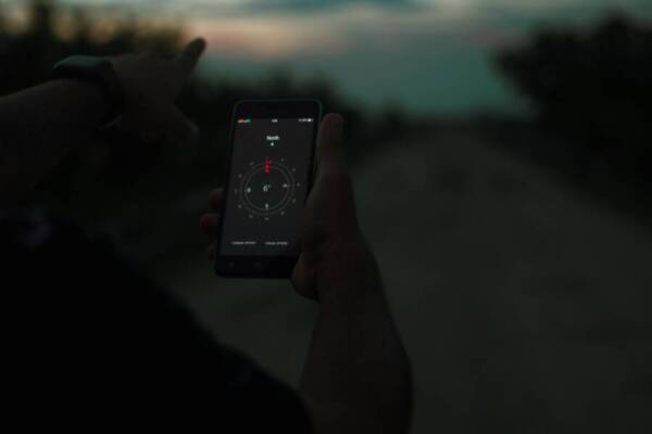 Person navigating using a smartphone compass app outdoors at twilight