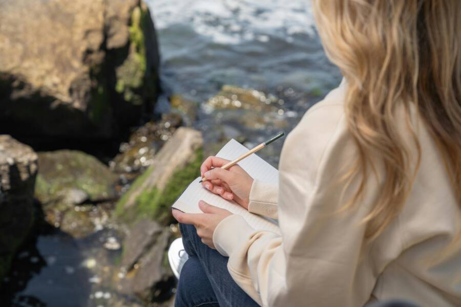 image of journaling and calm reflection by the shore